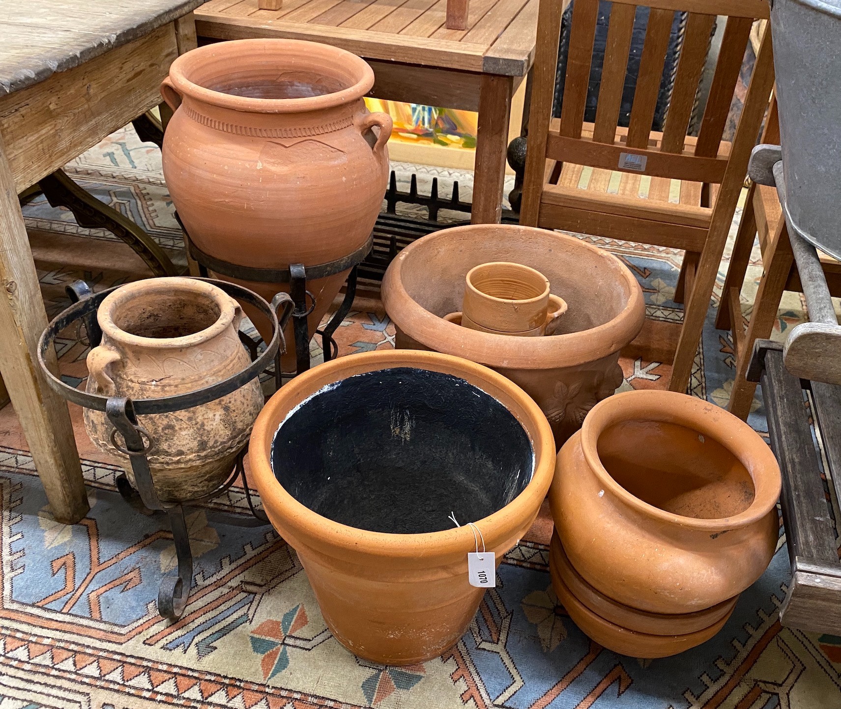 Eight assorted terracotta garden planters and two stands, largest diameter 49cm, height 40cm